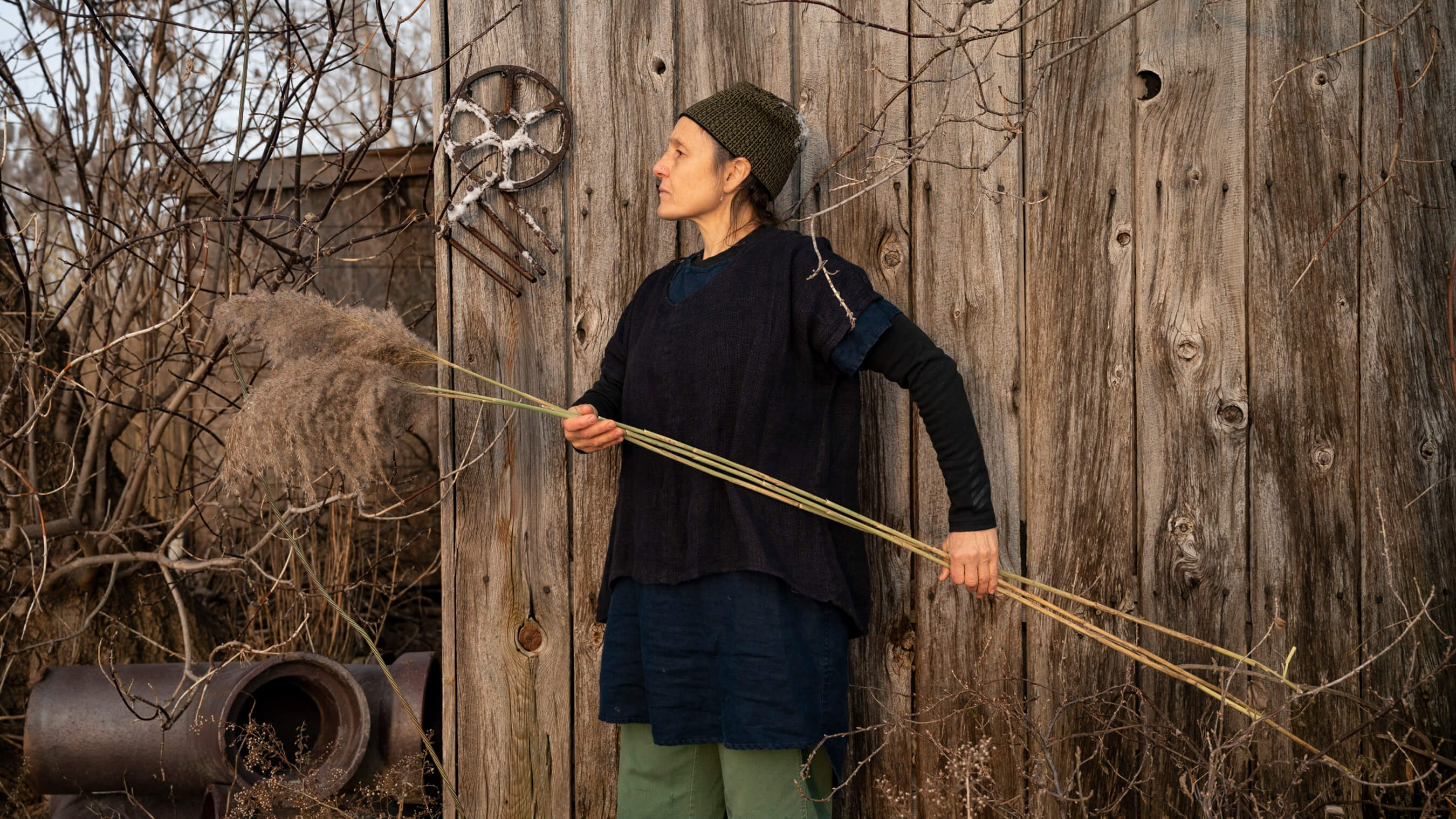 holding straw in front of shack