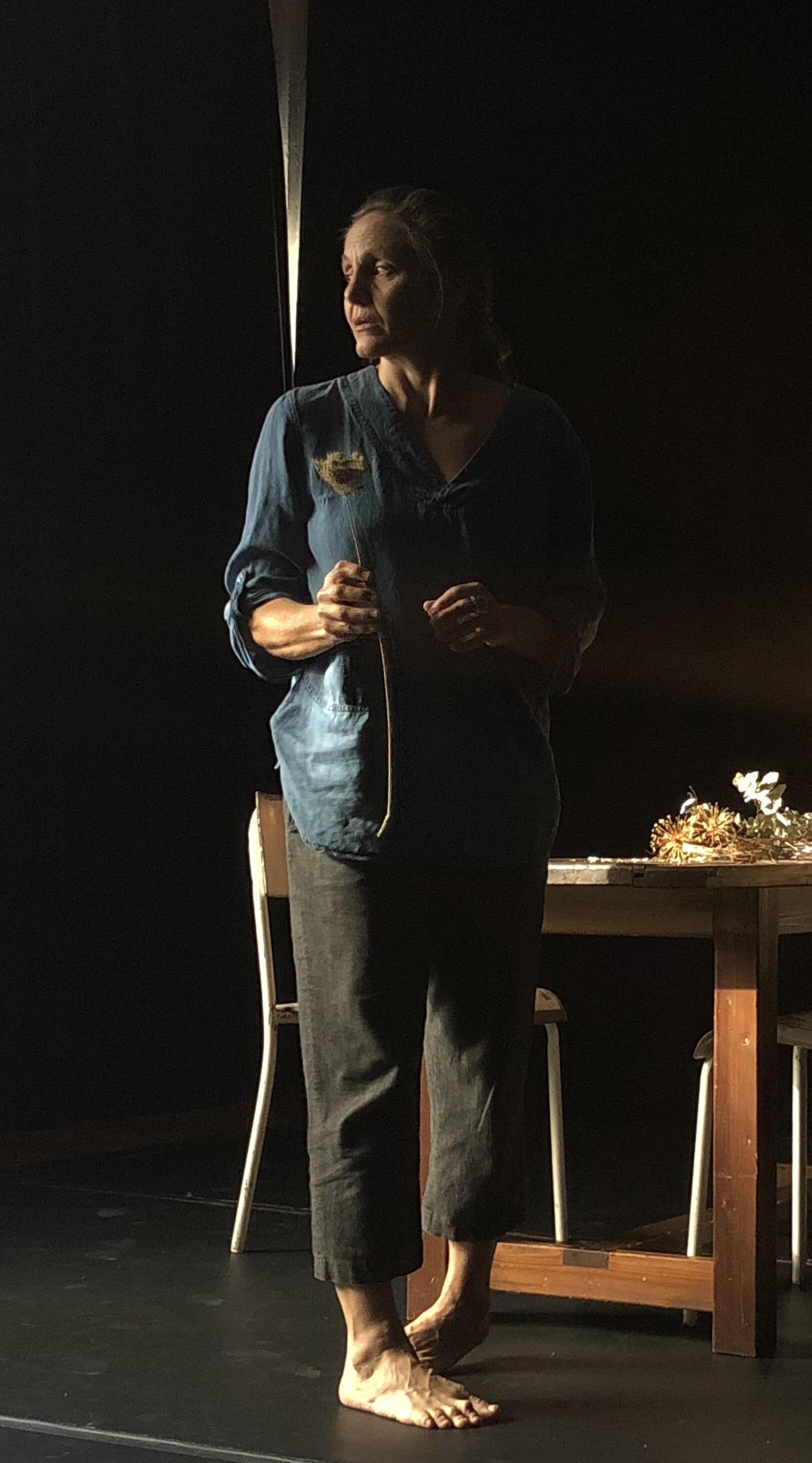 standing infront of table holding single dried flower